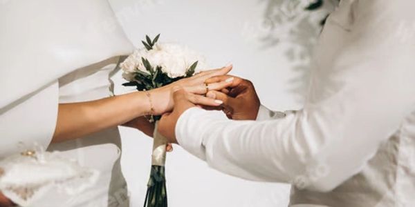 Two people exchanging rings during a wedding ceremony.
