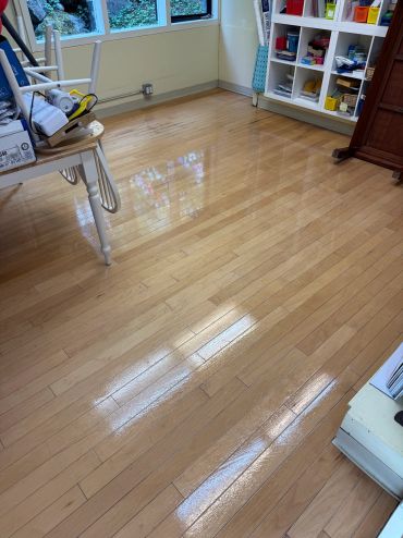 Shiny wooden floor in a cluttered room.