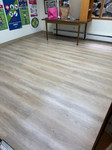 Room with wood-style flooring and posters on the walls.