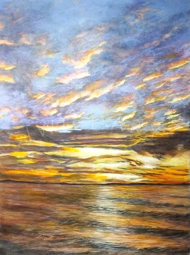 Hues of yellow paint a spectacular Winter Sunset in Mexico The sky and clouds darken the wave tips