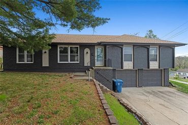 Single-story house with dark brick exterior and double garage.