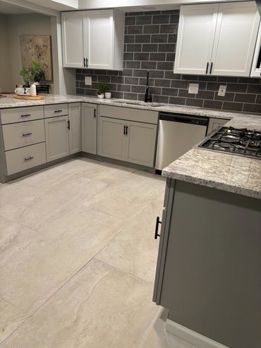 Modern kitchen with gray cabinets and granite countertops.
