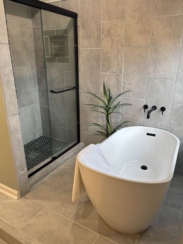 Modern bathroom with a freestanding tub and glass shower.