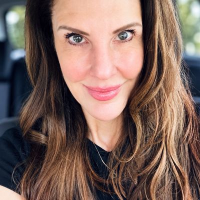 Close-up of a smiling woman with long brown hair.