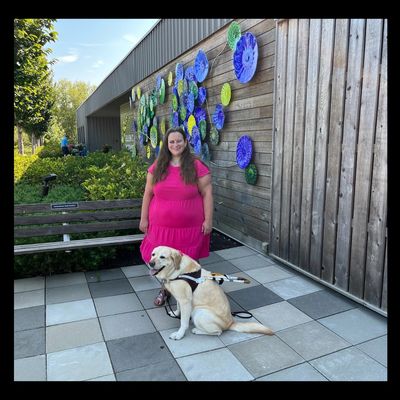 Photo of author Jessica Lee Minneci and service dog (Joyce) , both bursting with smiles on patio.