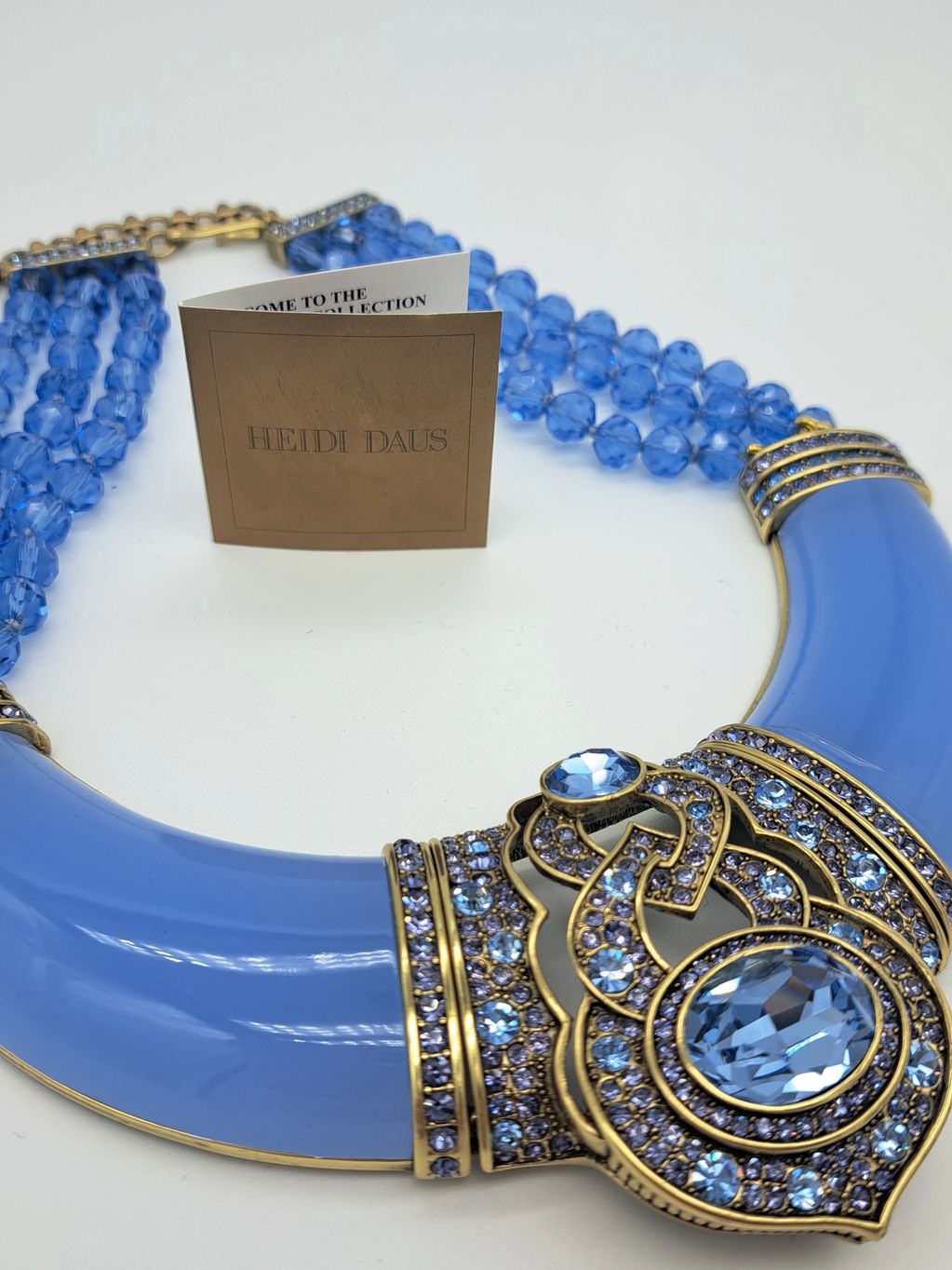 Heidi Daus blue statement necklace with intricate gold and gemstone details.