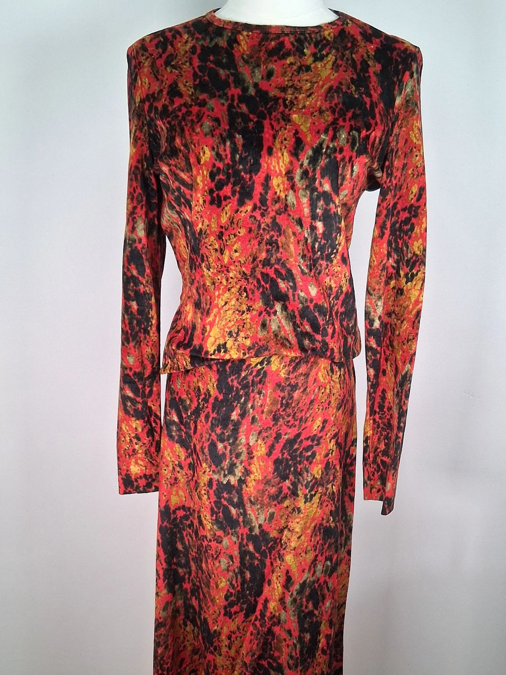 Two-piece outfit with vibrant red, black, and yellow abstract pattern.