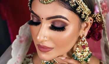 Close-up of a bride with intricate makeup and traditional jewelry.