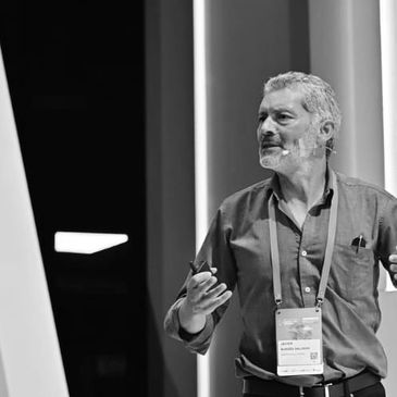 Hombre dando una presentación con micrófono en blanco y negro.