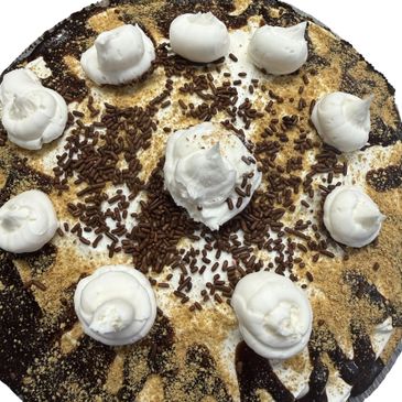 A round dessert topped with whipped cream, chocolate sprinkles, and graham cracker crumbs.