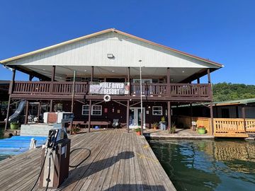 Two-story lakeside building with a dock and clear blue sky.