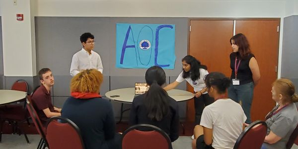 A group of students engaged in a classroom discussion with a presentation.