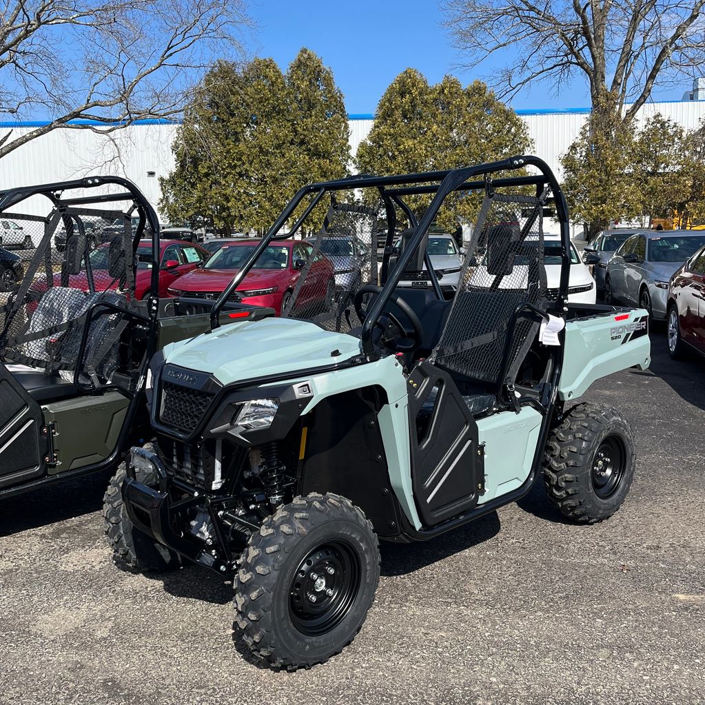 A light blue Honda Pioneer 520 off-road utility vehicle parked outdoors.