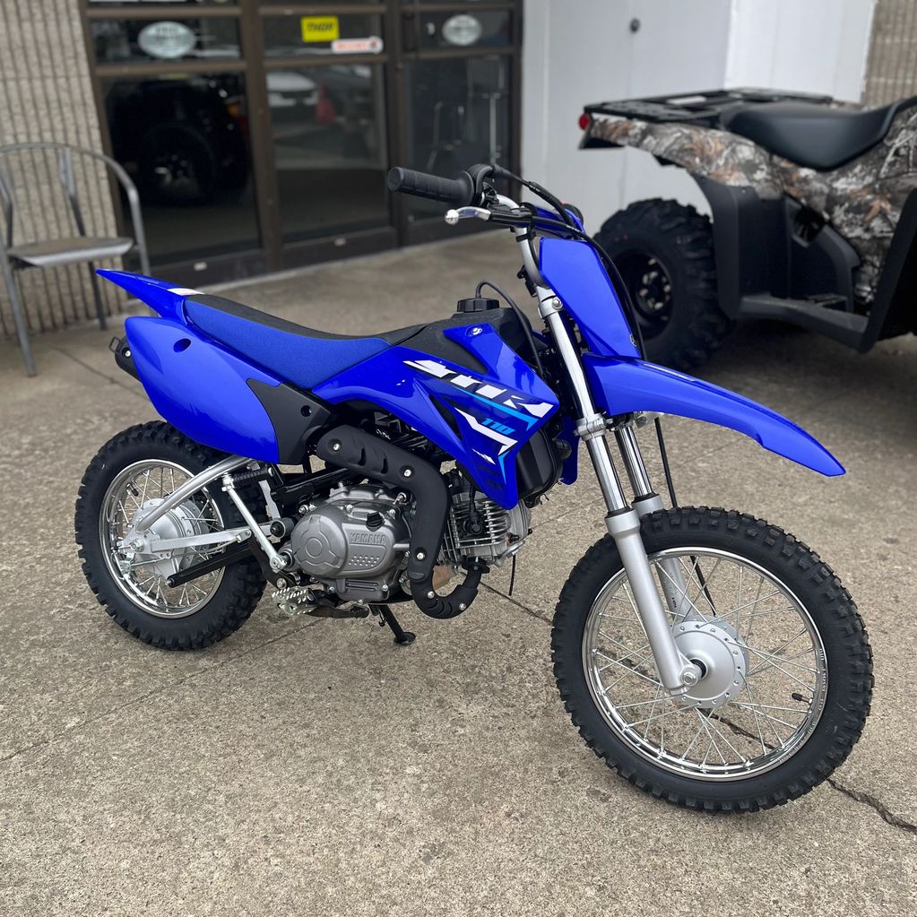 A blue Yamaha dirt bike parked on a concrete surface.