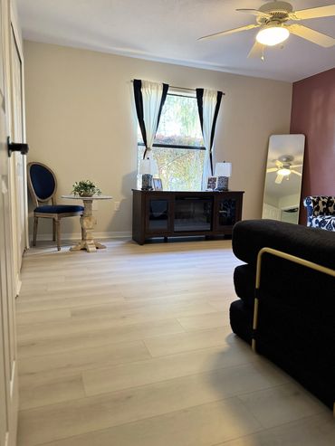 Bright living room with light wood flooring and elegant furniture.
