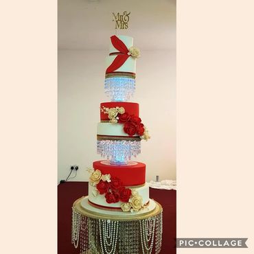6 tier wedding cake with red & cream flowers and swag. Asian wedding cake
