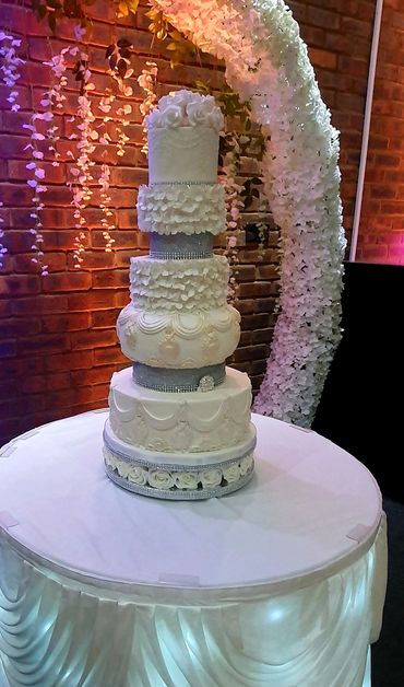 5 tier wedding cake with roses as toppers and with light antique gold dust.