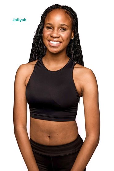 Young woman in black athletic wear smiling.