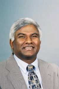 An Image of Dr. Rao in a grey blazer and blue/black tie smiling. 