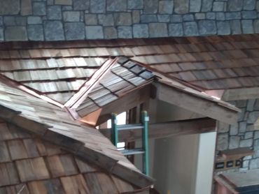 Rustic wooden roof with stone wall background and a green ladder inside.