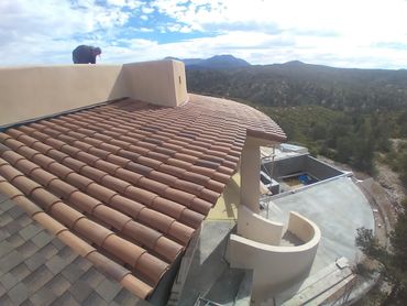 Person working on a rooftop with scenic mountain views.