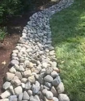 French drain topped with white river rock for Drainage remediation.