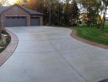 Concrete driveway with a stone paver border.