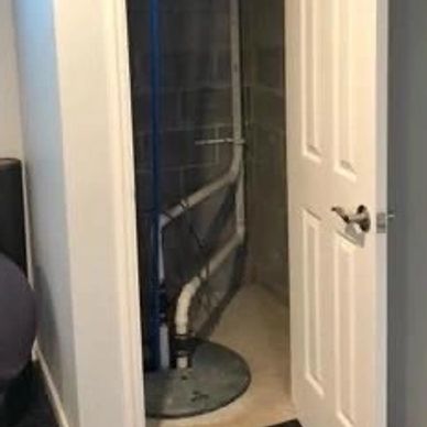 Sump pump enclosed with wall and door to resemble closet to hide from view - Basement waterproofing