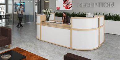 White & beech modular reception desk with glass sign in shelf and soft seating in brown