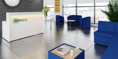 White reception desk with led lighting and blue modular seating.