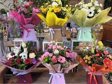 Colorful flower bouquets arranged on display with price tags.