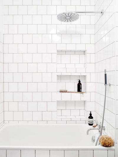 bathroom remodel with built-in shampoo soap shower niches tiled with white square subway tile