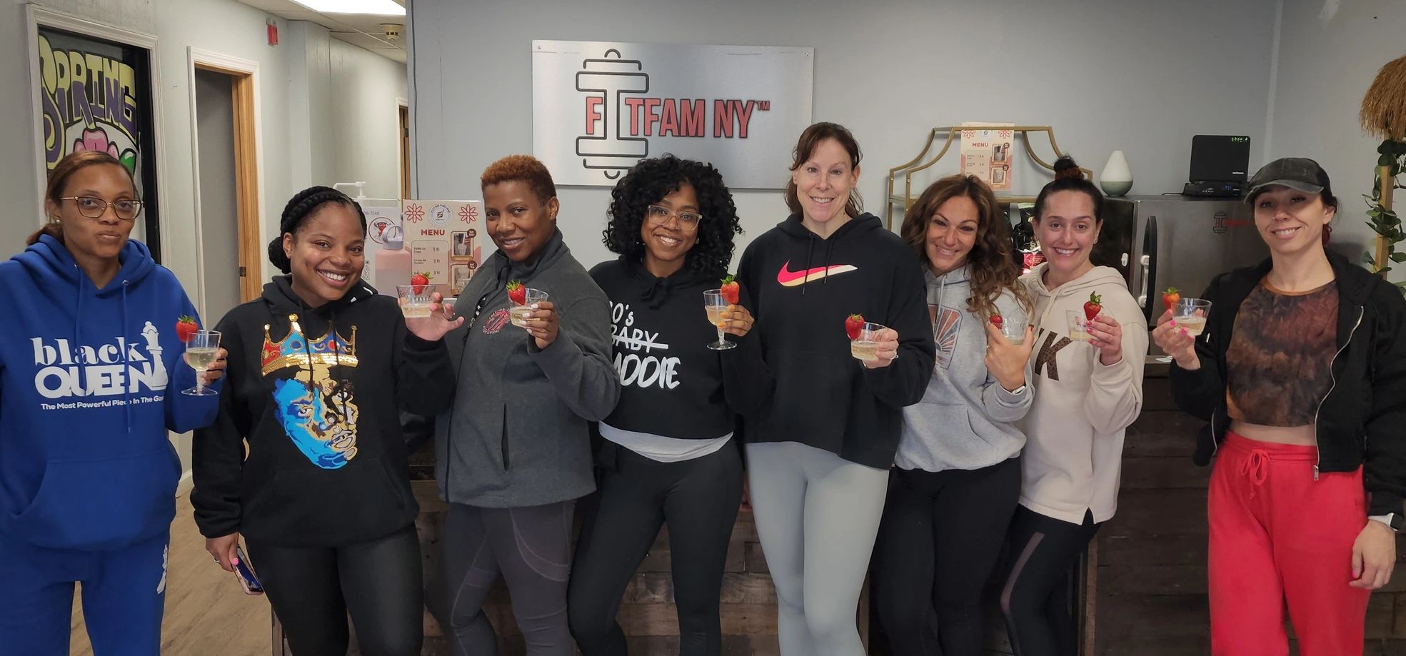 Group of women holding drinks with strawberries at FitFam NY.
