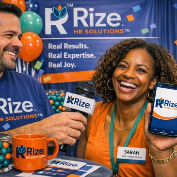 Smiling woman shows Rize HR Solutions app, man holds microphone at promotional event.
