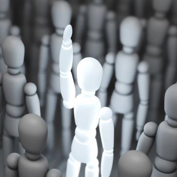 A white mannequin raising its hand among gray mannequins.