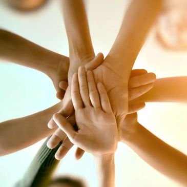 Multiple hands stacked together symbolizing unity and teamwork.