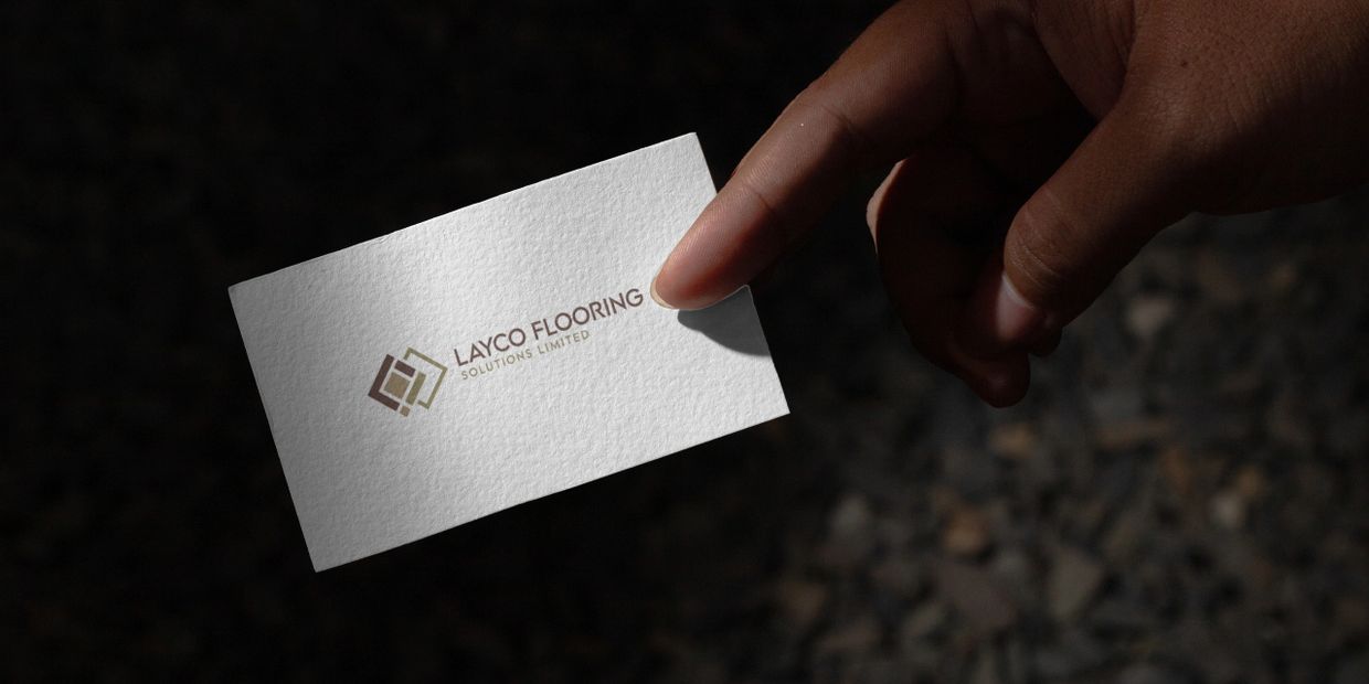 Hand holding a business card for Layco Flooring Solutions Limited.