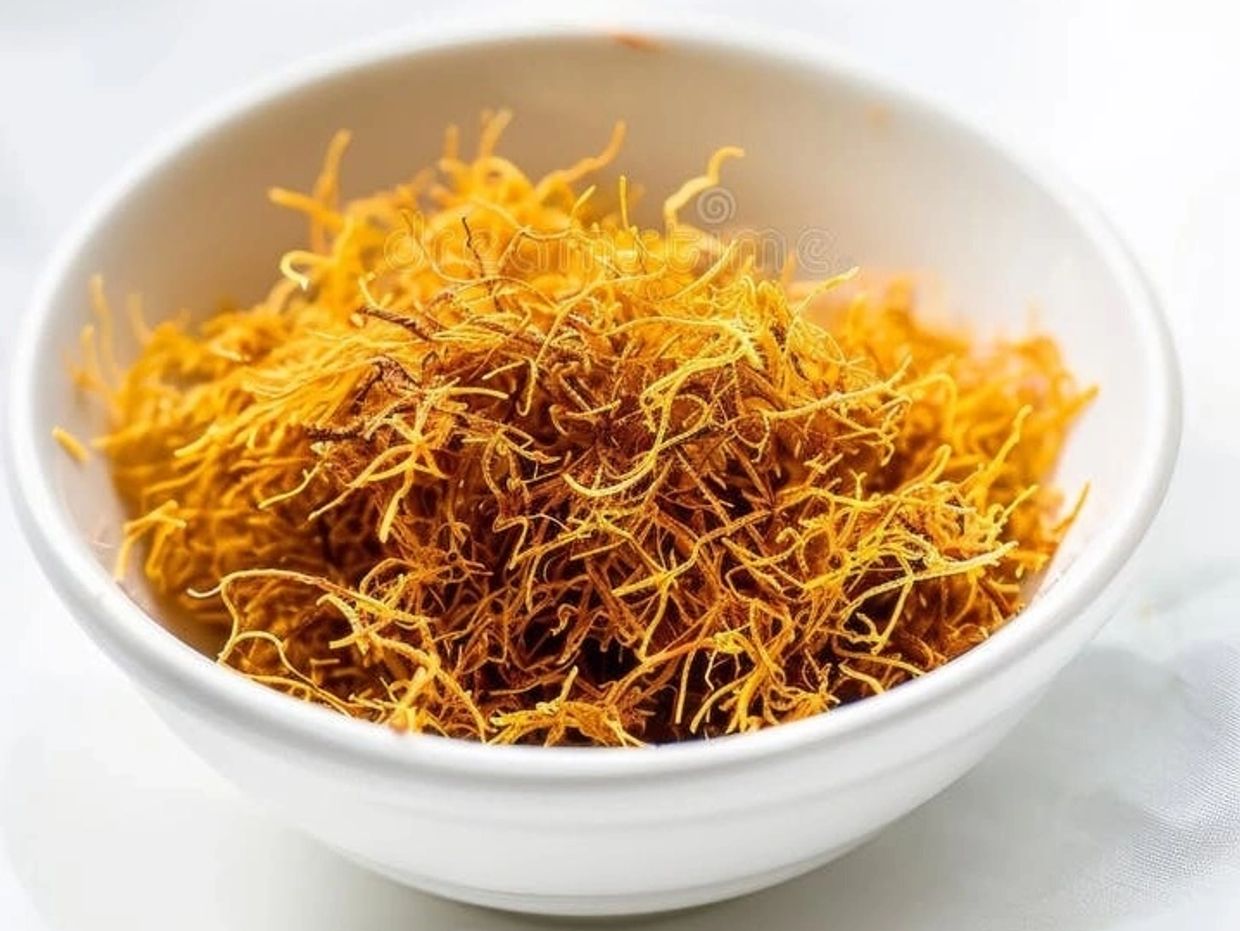 A bowl filled with bright orange dried saffron threads.