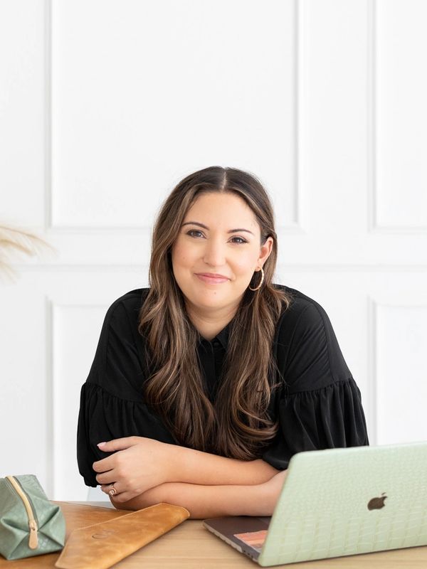 Farah Downs, licensed school psychologist, smiling at desk in private practice workspace.