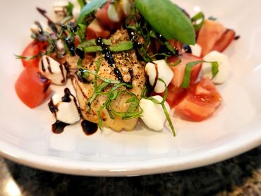 Caprese salad with fresh tomatoes, mozzarella, basil, and balsamic glaze.