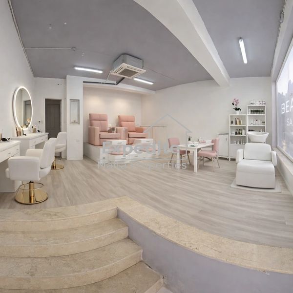 Modern beauty salon with pink and white decor and comfortable seating.