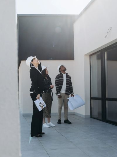 Architects inspecting a building exterior with blueprints.