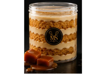 Layered caramel dessert in a clear jar with caramel squares.