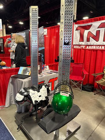 Football gear displayed on a metal frame at a trade show booth.