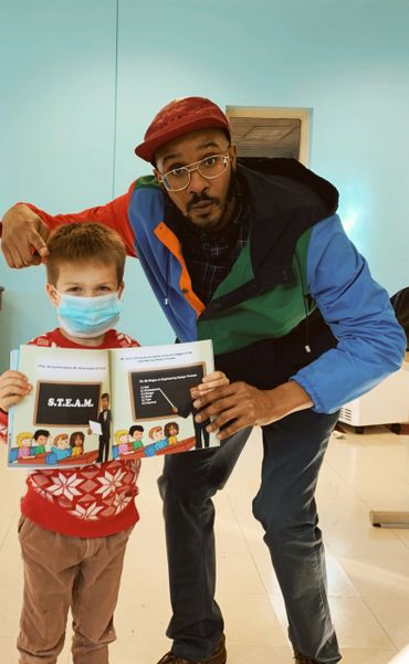 A man and a child holding a book about S.T.E.A.M. education.