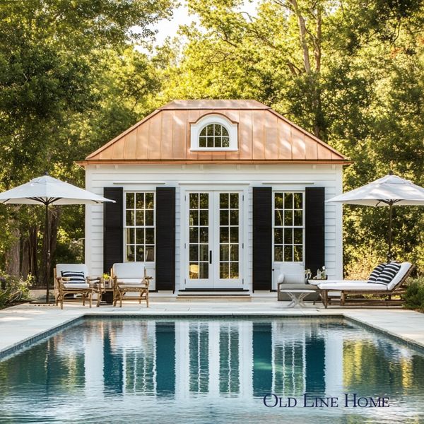 Traditional pool house with symmetrical architecture, copper roof and refined outdoor living space.