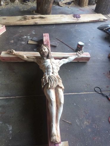 Wooden sculpture of Jesus on the cross in a workshop.