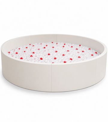 Round beige ball pit filled with white and red balls.