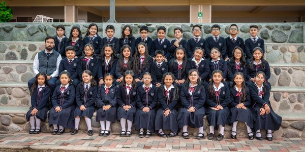School group photo with students and a teacher in uniform.