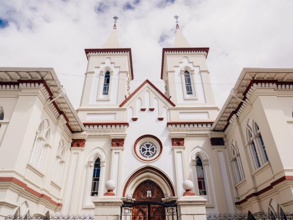 Front view of a white church with twin towers and ornate windows.